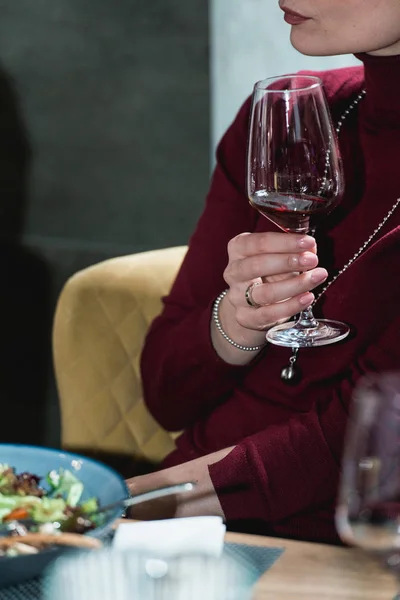 Woman holds glass of red wine. people consider the color of the wine and try how it smells in different glasses — Stock Photo, Image