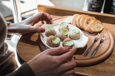 Salyangoz geleneksel seramik içinde otlar tereyağlı ekmek bir ahşap tahta üzerinde pan. Şarap