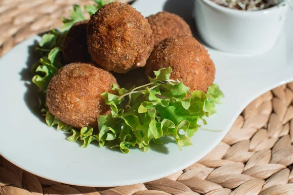 Großaufnahme eines Tellers mit spanischen Kroketten, serviert mit Salat und Soße — Stockfoto