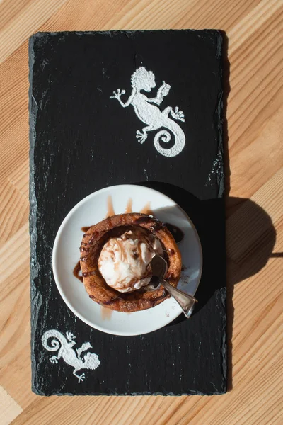 Traditional Mexican dessert churros served with ice cream on white plate on wooden table