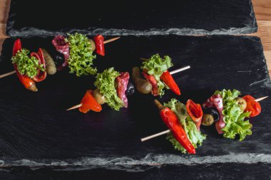 İspanyol aperatif, salam, zeytin, turşu, yeşil ve kırmızı biber turşu ile şiş üzerinde banderillas