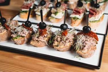 Beyaz tabakta ile tuna, kurutulmuş domates, zeytin ve pesto sos, geleneksel İspanyol yemek, lezzetli pinchos