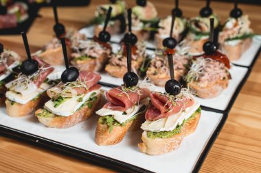 ton balığı, chorizos, somon, yumurta, Kuru domates, avokado, somon, pastırma, lezzetli pinchos Hamon, Brie peynir, zeytin ve Pesto sos, geleneksel İspanyolca snack