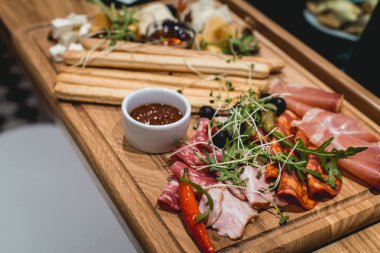 Peynir tabağı: Emmental, Camembert peyniri, mavi peynir, ekmek sopa, ceviz, zeytin ahşap tablo