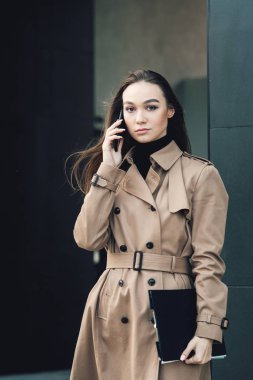 Elinde dosyası olan kendine güvenen genç bir iş kadını. Açık havada. şehir manzarası