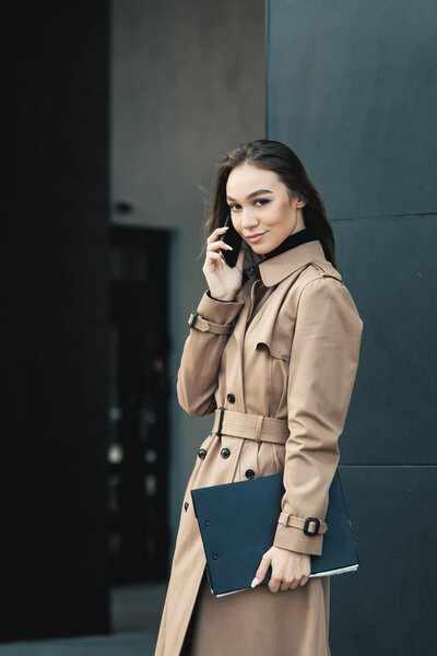 Self-confidence young business woman with file in a hand. outdoor. cityscape