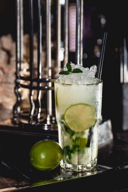 Bardaki masada bir bardak soğuk mojito. parlak ışık