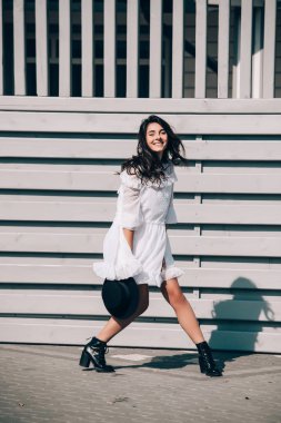 Modayı takip eden beyaz elbiseli genç hippi kadının hayat tarzı portresi.