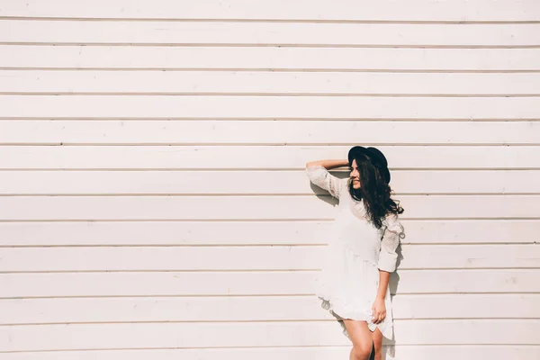 Ritratto di giovane donna hipster alla moda, vestito bianco alla moda, cappello nero e stivali — Foto Stock