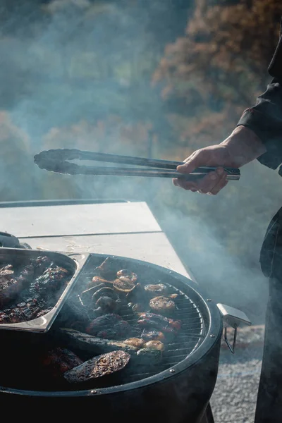 Grilování masa nad uhlím na přenosném grilu se zeleninou — Stock fotografie