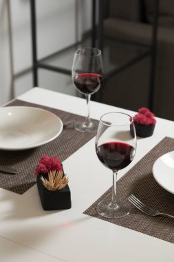 Akşam yemeği için cam eşyalar ve çatal bıçaklar. Bir kadeh şarap.
