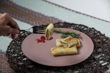 Kadın, ev yapımı geleneksel Ukrayna yemeği olan süzme etli krep yiyor..