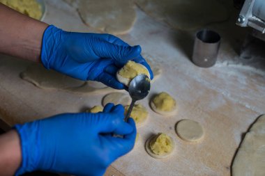 Ukrayna usulü patates ve süzme peynirli börek yapan kadın..