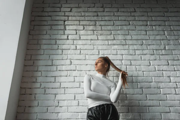 Modisches Brünettes Mädchen Weißem Pullover Und Schwarzer Lederhose Posiert Der — Stockfoto