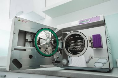 Tıbbi bir laboratuarda veya klinikte kapısı açık buharlı sterilizatör otoklavisi.