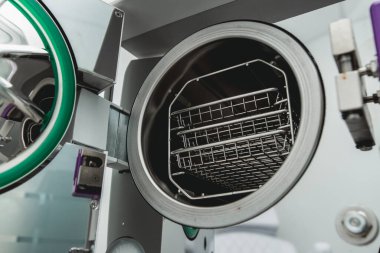 Tıbbi bir laboratuarda veya klinikte kapısı açık buharlı sterilizatör otoklavisi.