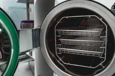 Tıbbi bir laboratuarda veya klinikte kapısı açık buharlı sterilizatör otoklavisi.