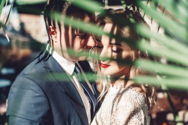 Gelin ve damat. Takım elbiseli bir adam ve düğün günü beyaz elbiseli sarı saçlı bir kadının yakın plan portresi..