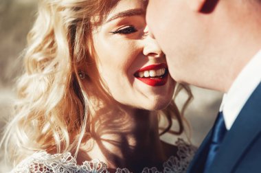 Gelin ve damat. Takım elbiseli bir adam ve düğün günü beyaz elbiseli sarı saçlı bir kadının yakın plan portresi..