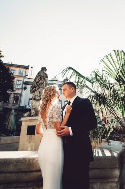 Gelin ve damat. Takım elbiseli bir adam ve düğün günü beyaz elbiseli sarı saçlı bir kadının yakın plan portresi..