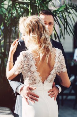 Gelin ve damat. Takım elbiseli bir adam ve düğün günü beyaz elbiseli sarı saçlı bir kadının yakın plan portresi..