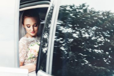 Arabanın camında gülümseyen güzel bir gelinin yakın plan portresi..