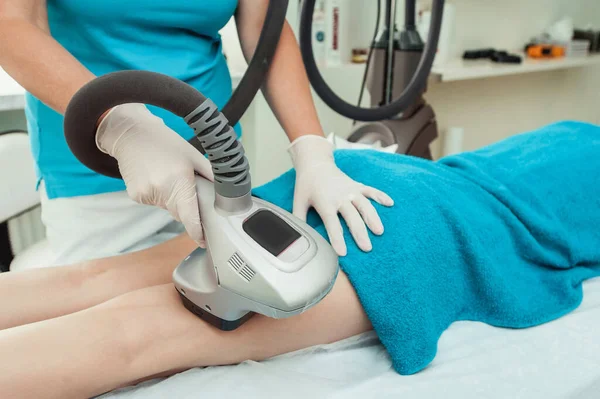 一名戴白色手套的皮肤科医生用蓝色毛巾对一名妇女的腹部进行射频移植手术时拍摄的照片 — 图库照片