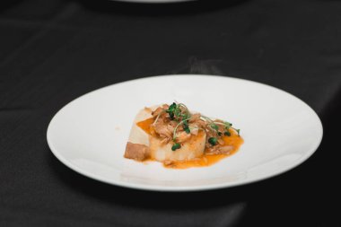 Bir parça ev yapımı ekmeğin üzerinde pişmiş tavşan yiyen bir kadın..