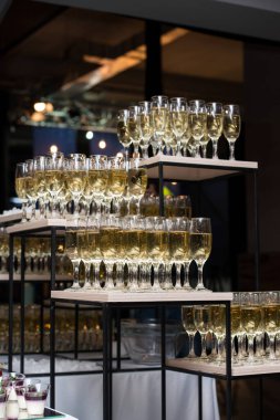 Kulede bir sürü şampanya kadehi var. Arkaplanda parıltılar