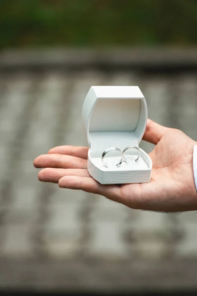 那人手上拿着结婚戒指的盒子 — 图库照片