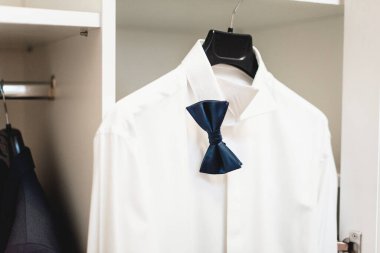 Gardıropta asılı duran papyonlu beyaz gömlek. düğün günü