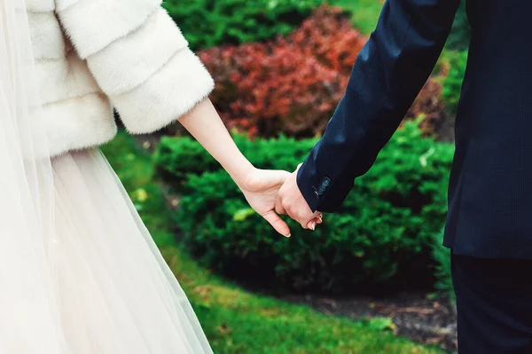 Een jong stel dat elkaars hand vasthoudt. Huwelijksdag. Buiten — Stockfoto