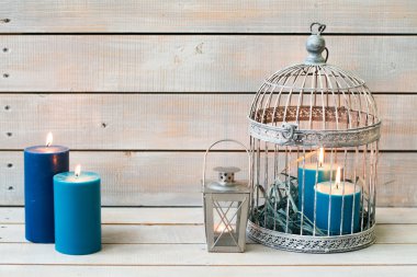 Fener ve mavi mum beyaz ahşap zemin üzerinde. Kopya girintili