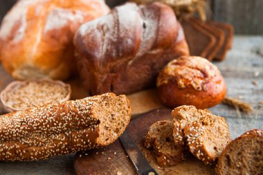 Taze ekmek dilimi ve kırsal masada bıçak kesme.
