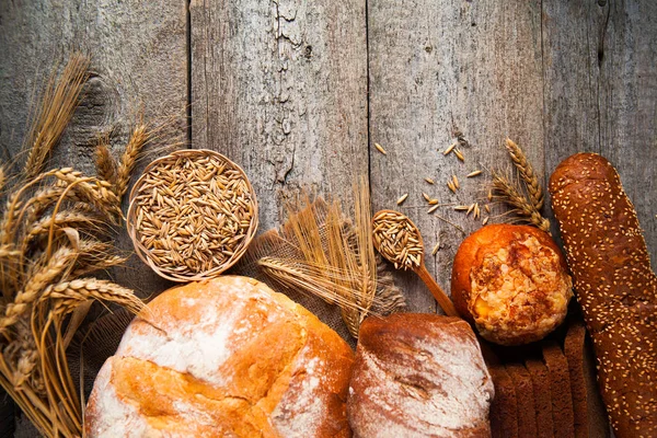 Assortiment van gebakken brood op oude houten tafel achtergrond — Stockfoto