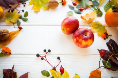 Kırmızı elma ve renk sonbahar yaprak Beyaz ahşap zemin üzerinde,