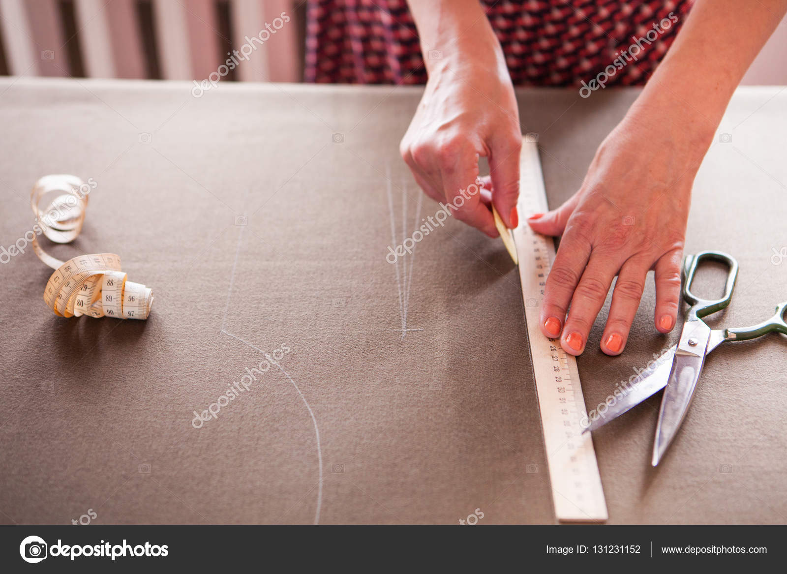 Close up. Hands woman Tailor working cutting a roll of fabric on