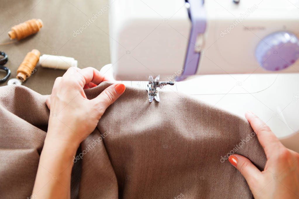 Woman tailor working on sewing machine. Hands. close up.  Tailor