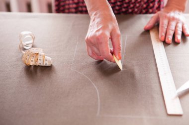 Yakın çekim. Eller kadın terzi bir rulo kumaş kesim çalışma