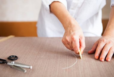 Yakın çekim. Eller kadın terzi bir rulo kumaş kesim çalışma