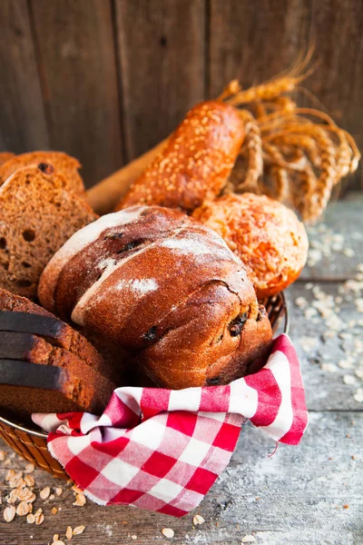 Diferentes panes frescos en canasta de mimbre sobre mesa rústica sobre madera — Foto de Stock