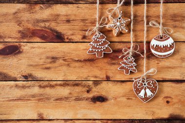 Eski ahşap arka plan üzerinde asılı gingerbread çerezleri. Düz yatıyordu