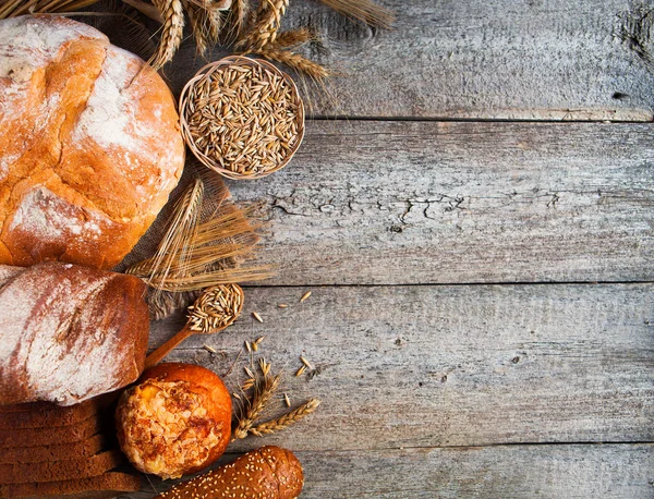 Surtido de pan horneado sobre fondo de mesa de madera vieja — Foto de Stock