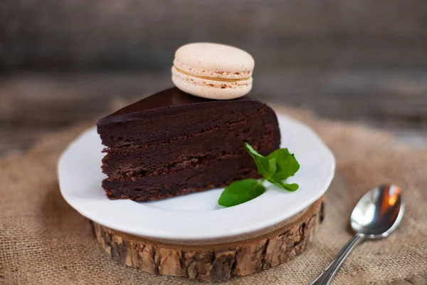 A piece of chocolate cake with fresh mint on the table, close-up — Stock Photo, Image