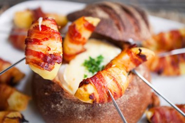 Lezzetli sıcak peynir fondü hizmet patates ile bir ekmek rulo ve