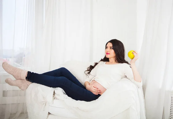 Gelukkig zwangerschap vrouw zittend op de Bank met groene appel, gezonde — Stockfoto