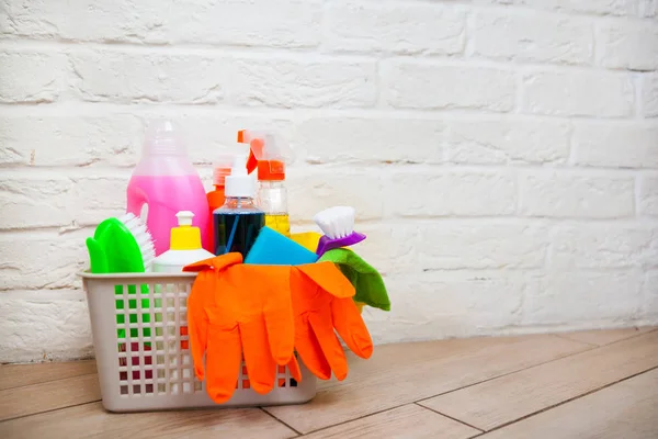 Basket with cleaning items on blurry background white citchen. C — Stock Photo, Image