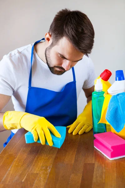 Fechar-se de homem jovem vestindo avental limpeza cozinha Superfície — Fotografia de Stock