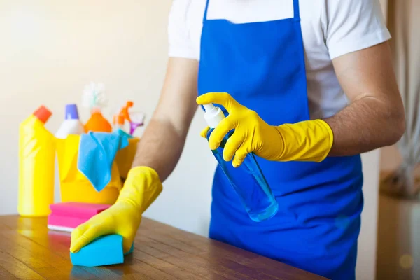 Fechar-se de homem jovem vestindo avental limpeza cozinha Superfície — Fotografia de Stock