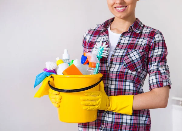 Jovem mulher bonita segurando ferramentas de limpeza e produtos em balde — Fotografia de Stock